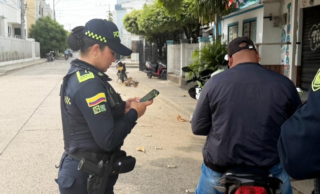 una uniformada realizando registro a vehículo mediante dispositivo PDA 