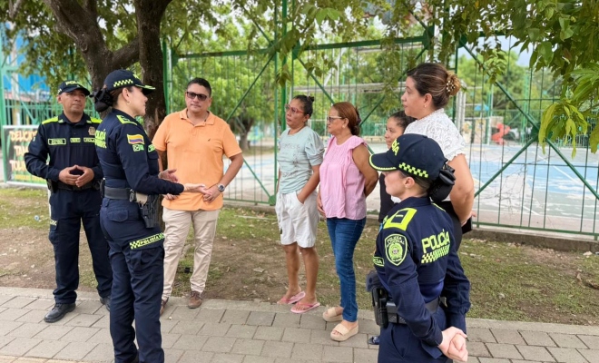 tres uniformados con personal de la junta accion comunal del barrio santa elena en  dialogo 