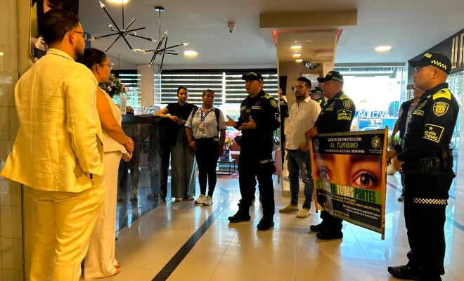 Tres funcionarios policiales brindando recomendaciones a un grupo de personas en sector hotelero