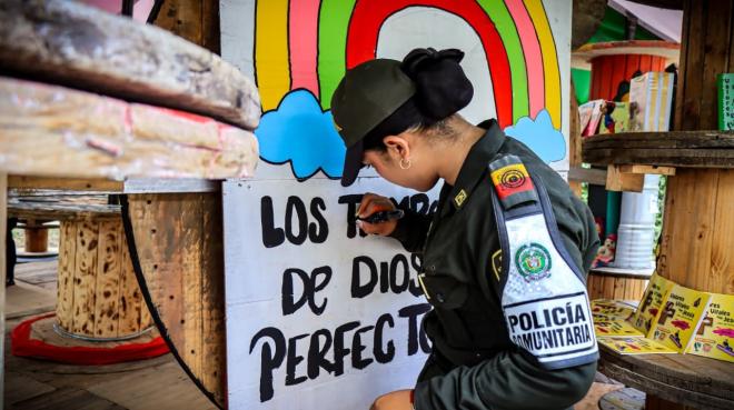 Auxiliar de Policía pintando un mural en el aula ambiental El Arca.