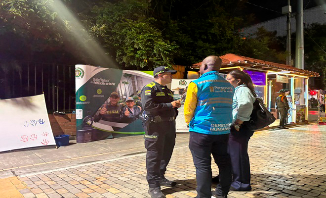 Un policía hablando con una mujer y un hombre  