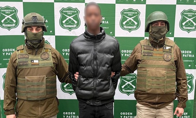 Un capturado custodiado por dos policías en Chile