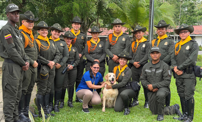 Funcionarios de Carabineros posan agrupados en el centro, acompañando a la adoptante de la canina Luna.
