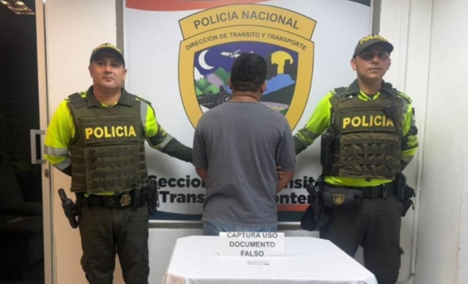 Dos funcionarios policiales con un ciudadano capturado 