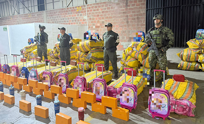 Dos policías y dos soldados custodiando mercancía de contrabando