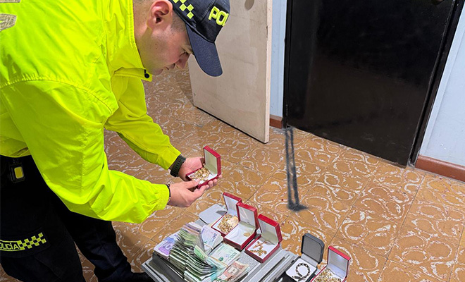 Policía revisando dinero y joyas de oro incautadas