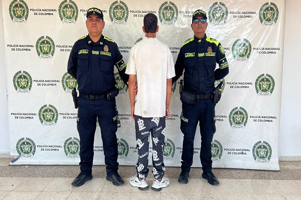 Dos uniformados de la Policía custodian a un adolescente aprehendido 