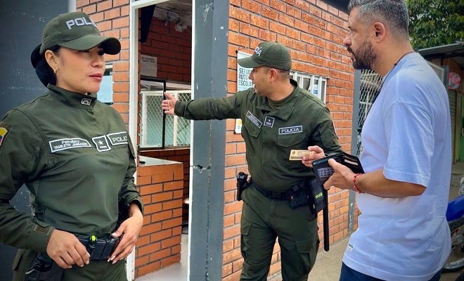 Dos policías brindan orientación a un ciudadano al ingreso del colegio asignado para votar