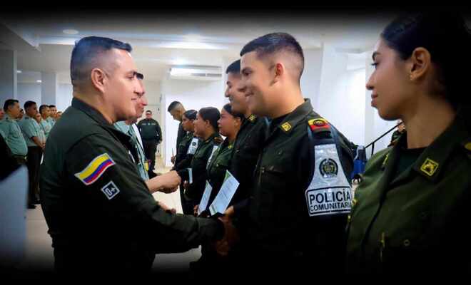 Señor coronel saluda y entrega reconocimiento a un auxiliar de policía.