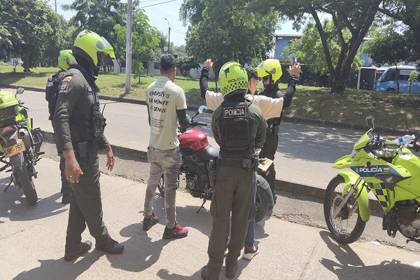 Cuatro Policías del GOES realizando solicitud de antecedes a persona y vehículo, como también registro a persona a dos ciudadanos en vía publica