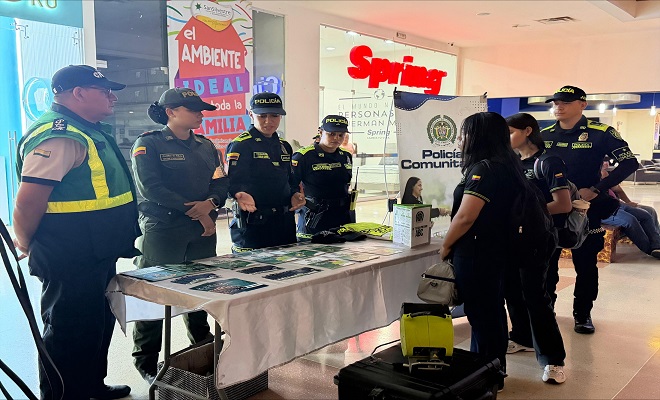Cuatro funcionarios de la Policía Nacional en compañía de un integrante de la Cívica de mayores realizando campaña de prevención dando a conocer la oferta institucional a dos ciudadanas en el centro comercial