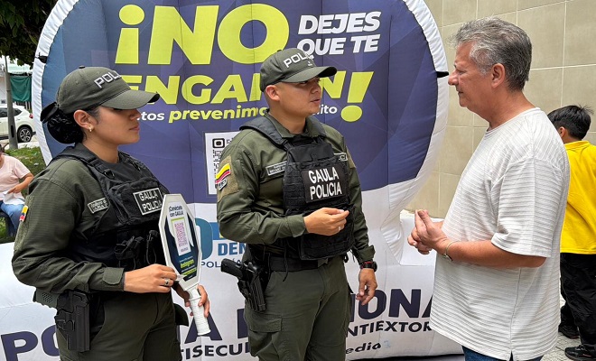 Dos funcionarios del grupo del GAULA de la Policía Nacional brindando campaña de prevención a un ciudadano