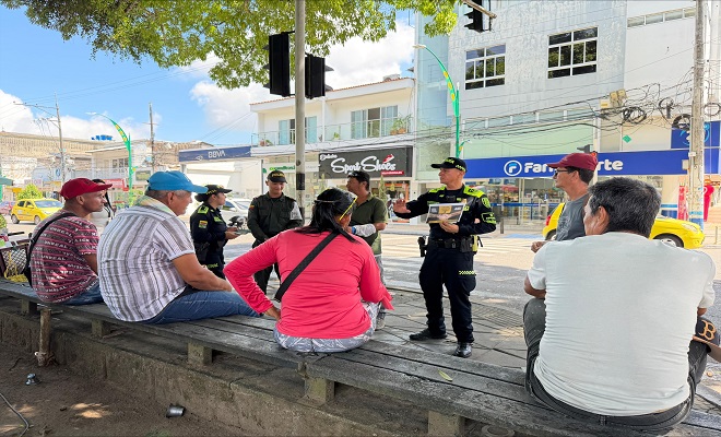 Tres funcionarios de la Policía Nacional realizando campaña de prevención al suicidio a seis ciudadanos en el sector comercial de Barrancabermeja.