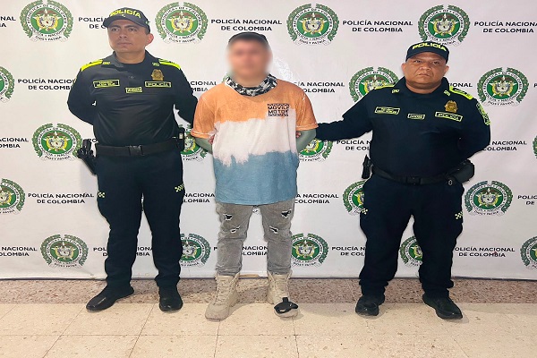 Dos policías custodian a un hombre capturado por orden judicial