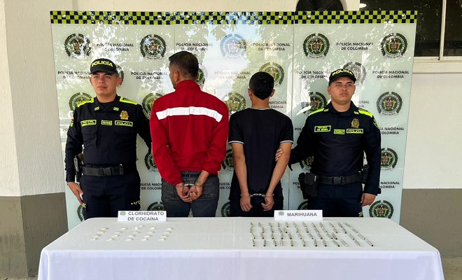 Dos policías con  dos personas Capturadas por tráfico de estupefacientes 