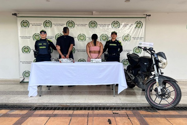 Dos Polic&iacute;as, dos capturados, una motocicleta incautada y mesa con dos armas de fuego incautadas