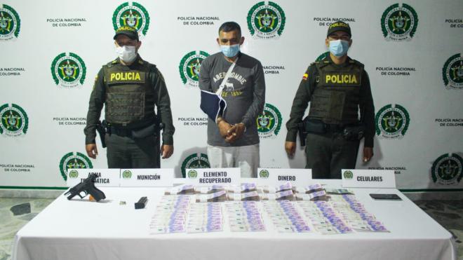 1 persona capturada-policías custodiando-dinero en efectivo incautado