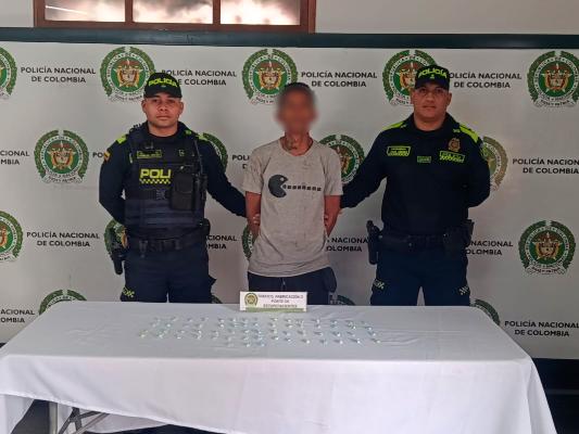 Hombre capturado con dos Policías al lado