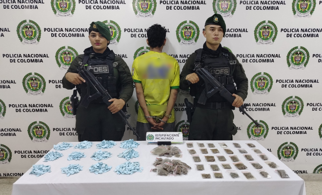 Hombre capturado en medio de dos Polic&iacute;as, en frente estupefacientes incautados