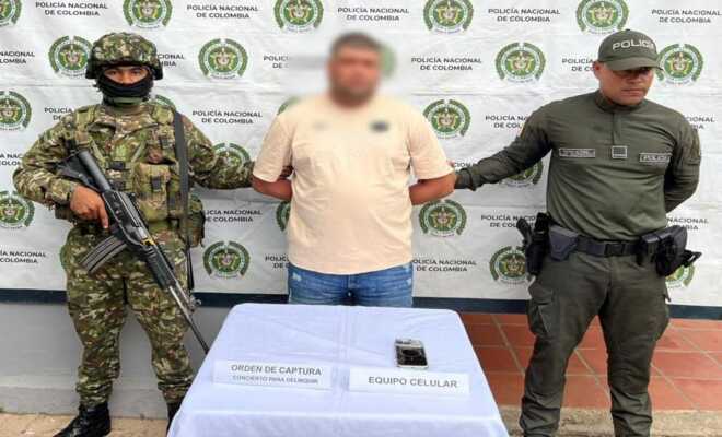 Un soldado y un policía custodian a un capturado alias mono