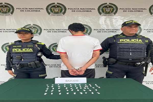 Dos Policías, un capturado, mesa con estupefacientes