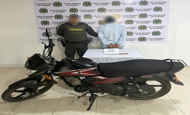 Polic&iacute;a junto a un hombre capturado y una motocicleta incautada