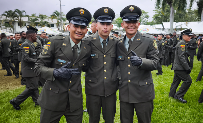 Tres policías graduados posando después de culminar la ceremonia