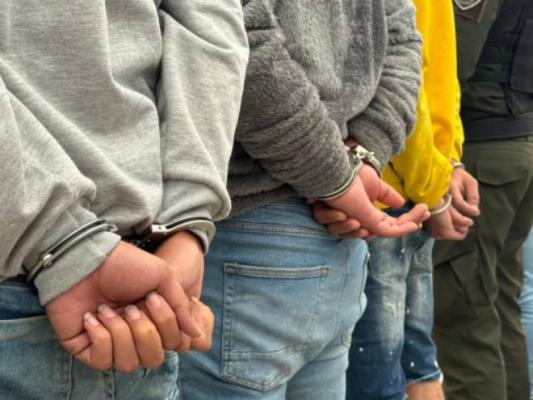 Tres personas capturadas de espaldas con esposas 