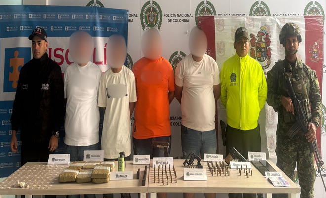 funcionario del CTI, ejercito nacional, uniformado de la sijin sujetan a cuatro capturados, encima de una mesa elementos incautados