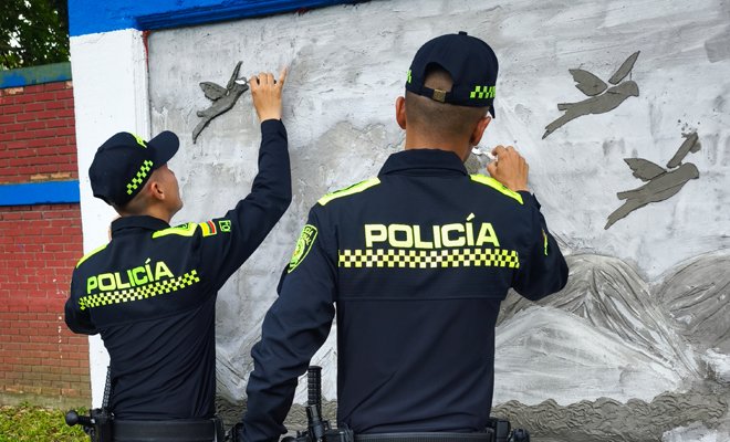 Dos Policías realizando un mural 