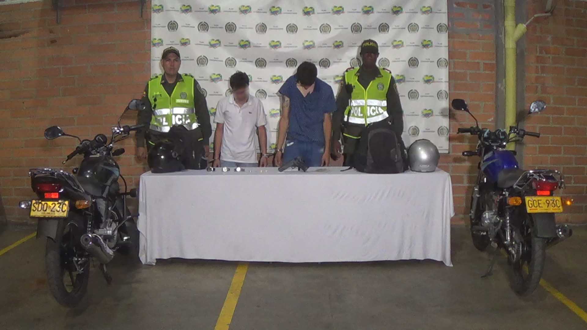 Dos personas capturadas custodiados por dos policías de la Sijin 