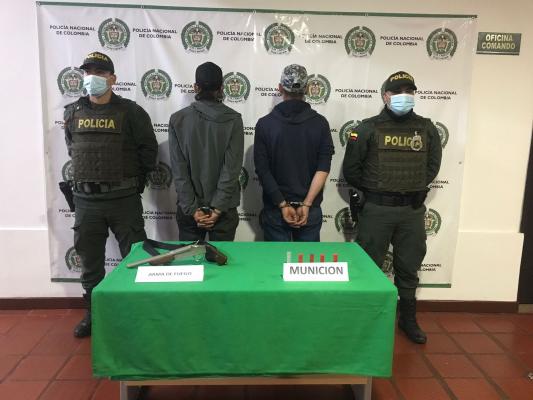 Dos hombres capturados con un arma de fuego 