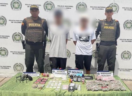dos policías al lado de dos hombres capturados