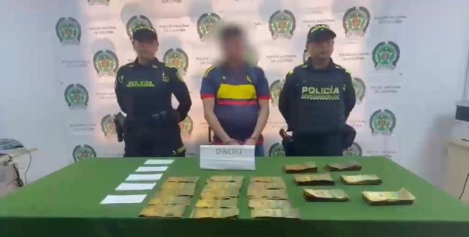 Dos policías al lado de un hombre capturado