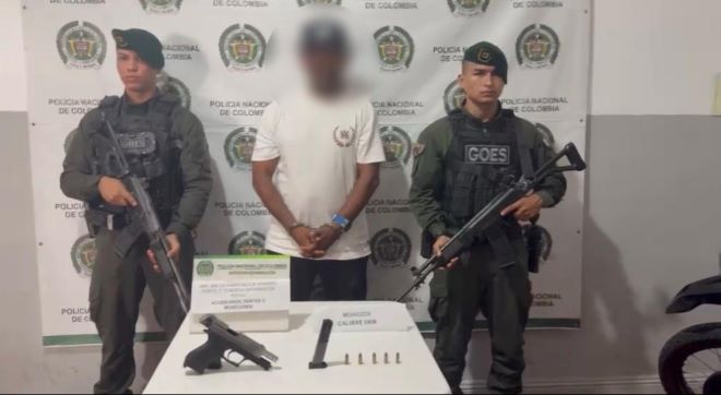Dos policías al lado de un hombre capturado