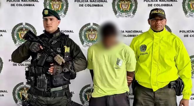 dos policías al lado de un hombre detenido