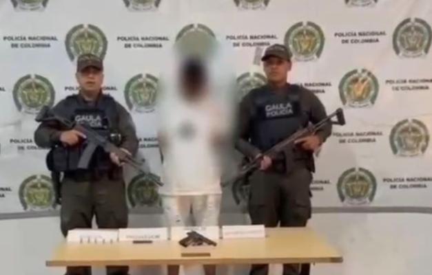 Dos policías al lado de un hombre capturado.