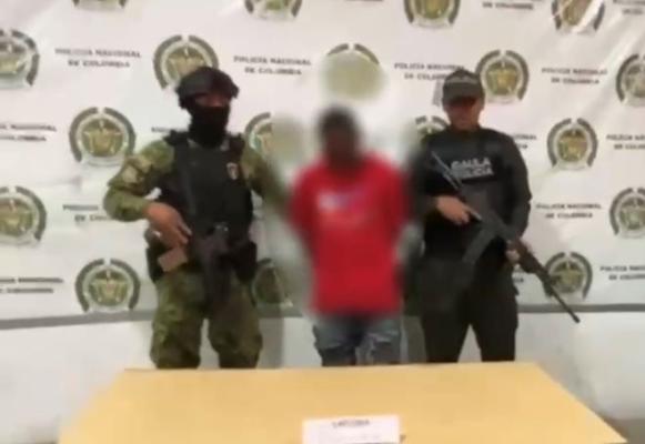 Dos polic&iacute;as al lado de un hombre capturado