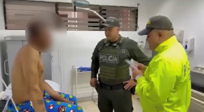 dos policías al lado de un hombre capturado