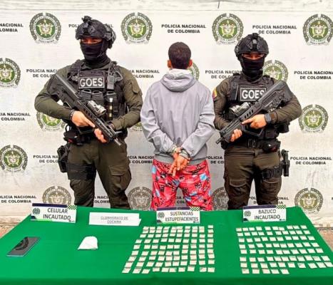 dos policías al lado de un hombre capturado con estupefacientes