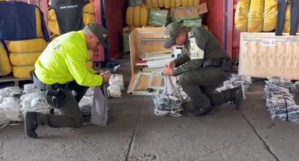 dos policías con mercancía incautada