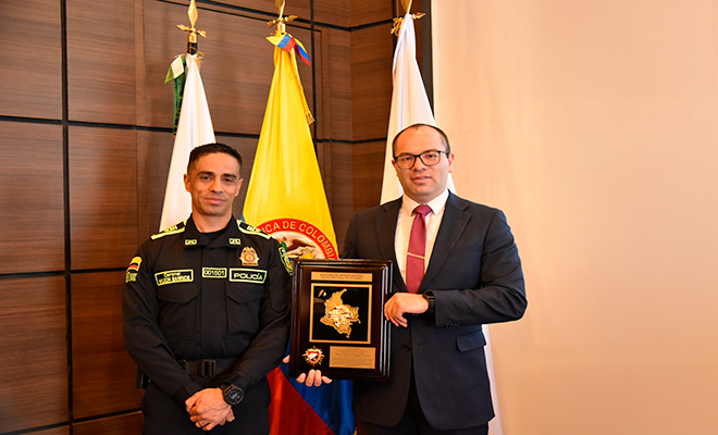 Entrega de reconocimiento durante jornada académica sobre regulación contable pública.