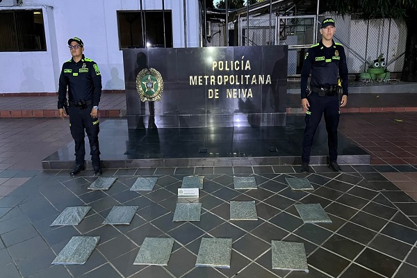 Dos policías junto a la marihuana incautada