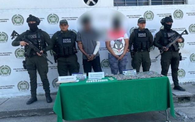 la policía nacional al lado de dos hombres capturados con estupefacientes