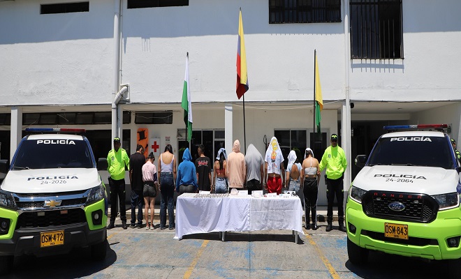 Policías custodian personas capturadas en la mesa material incautado, estupefacientes, dinero y arma de fuego 