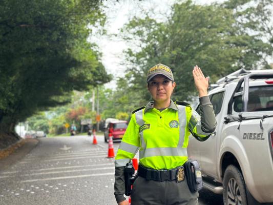 Mujer Policia en la vía en puesto de control a vehiculos