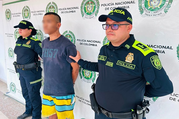 Dos policías custodian a un hombre capturado por hurto
