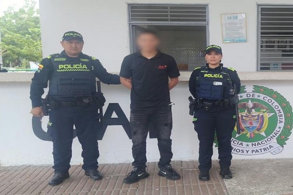 Dos policías custodian a un hombre capturado