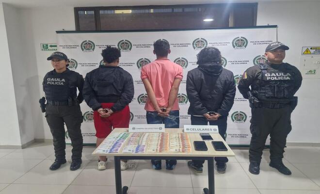 policias del gaula con tres personas capturadas y dinero incautado sobre una mesa