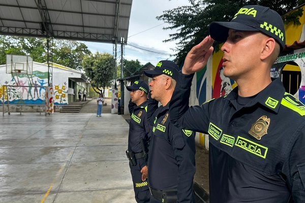 Tres uniformados de la Policía permanecen atentos durante el proceso de preconteo electoral